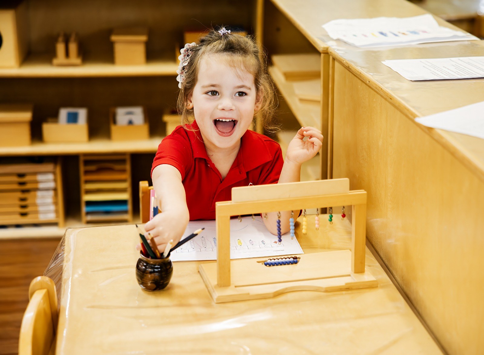 A child stamping with ink at an easel, laughing
