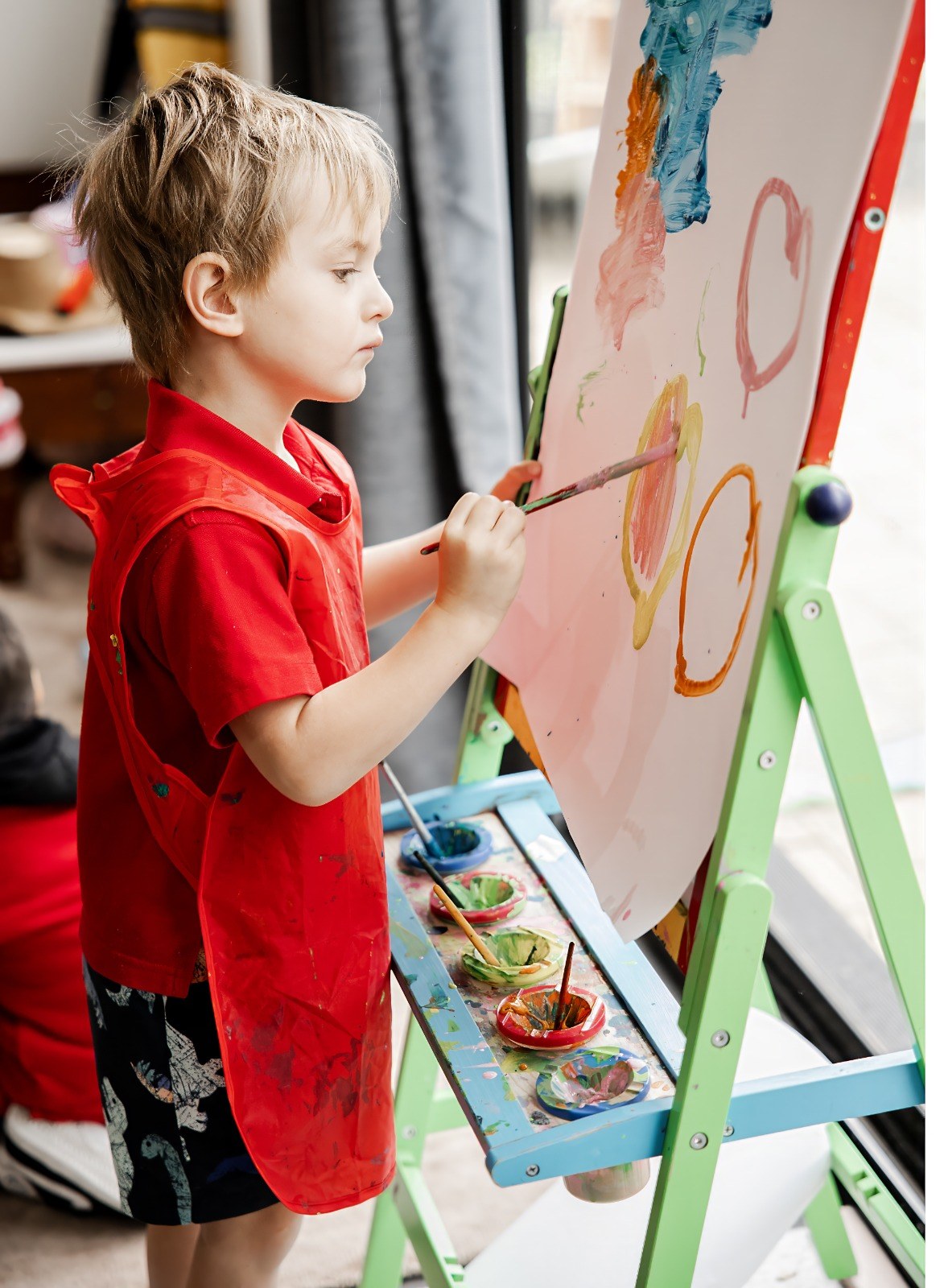 A child painting at the easel