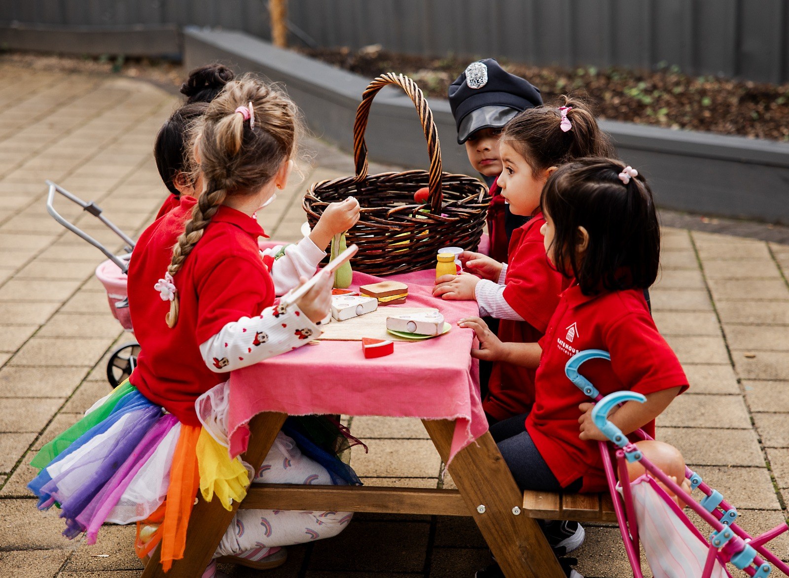 Children enjoying pretend tea party play at an outdoor table
