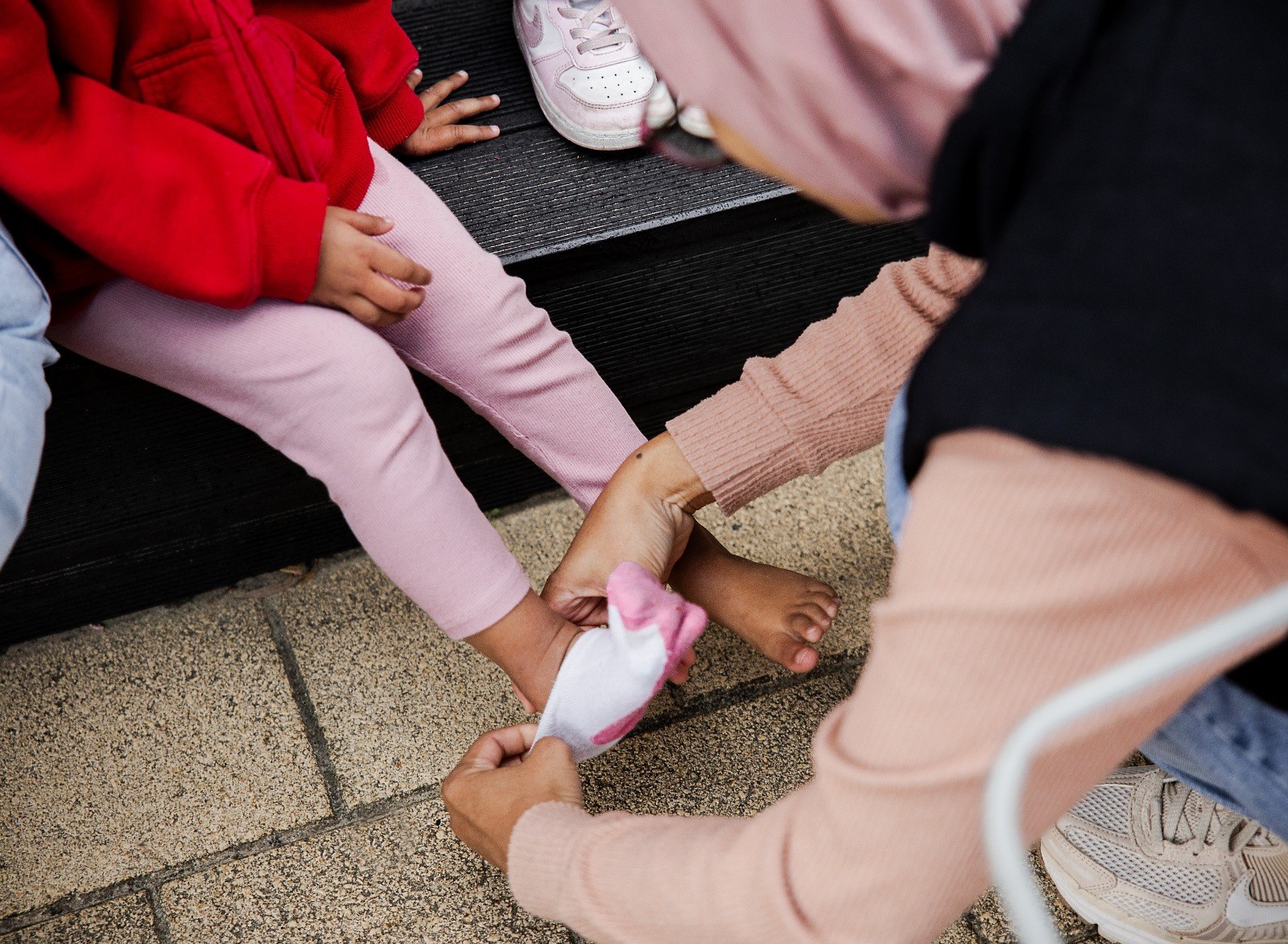 An educator helping a child with practical life dressing skills