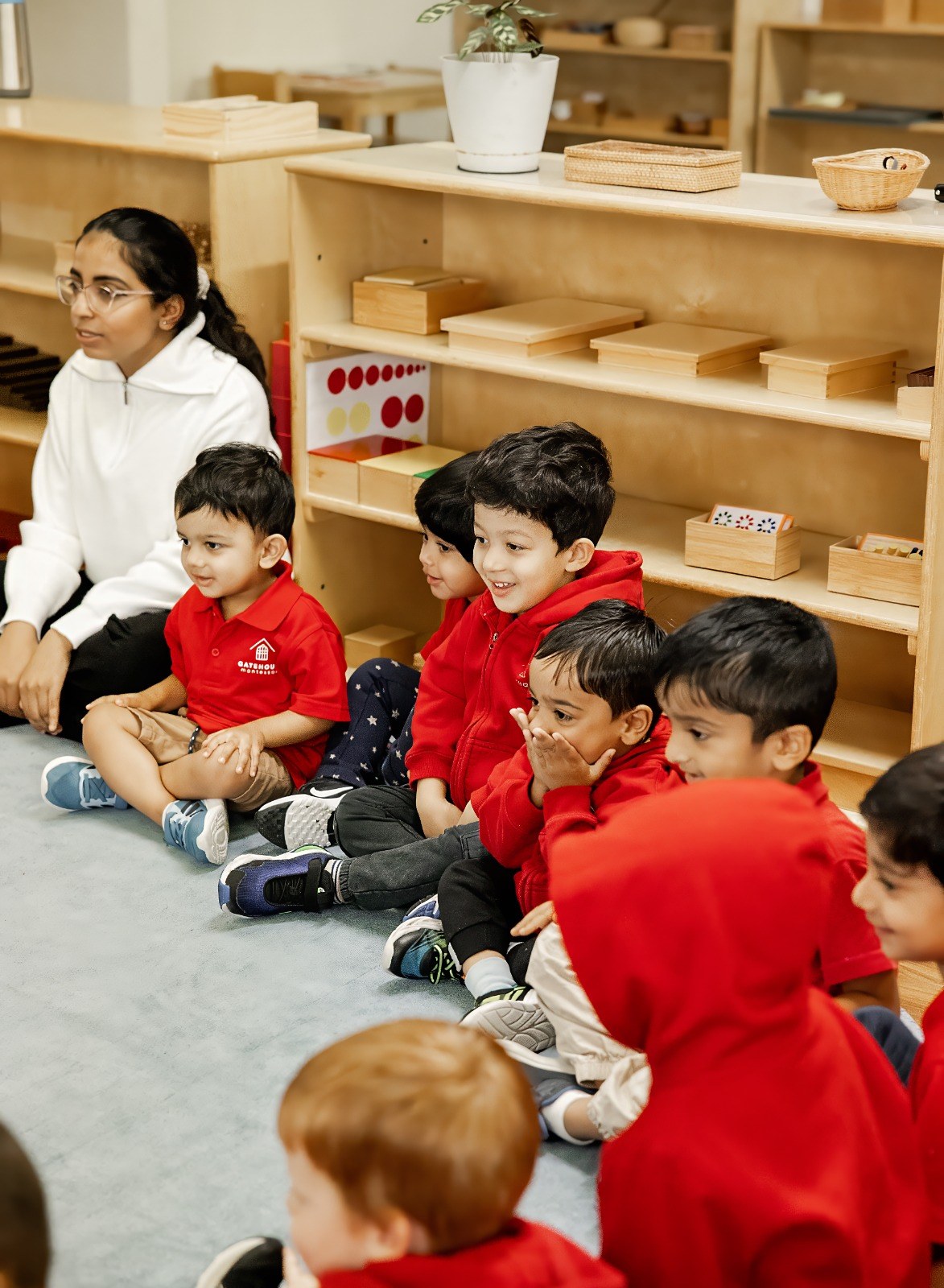 An educator leading a lesson with children seated on the floor