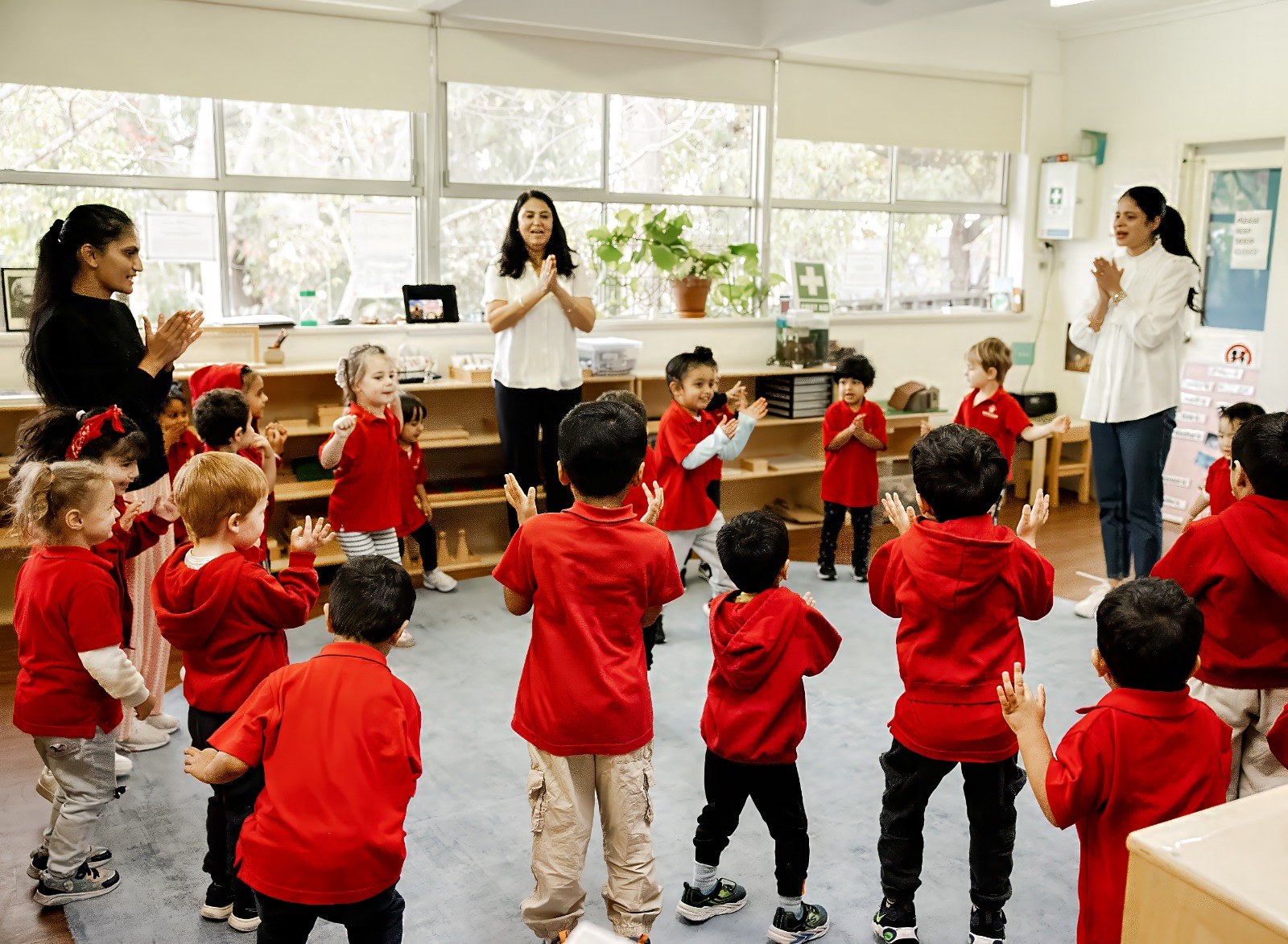 An educator guiding a line of children as they walk together