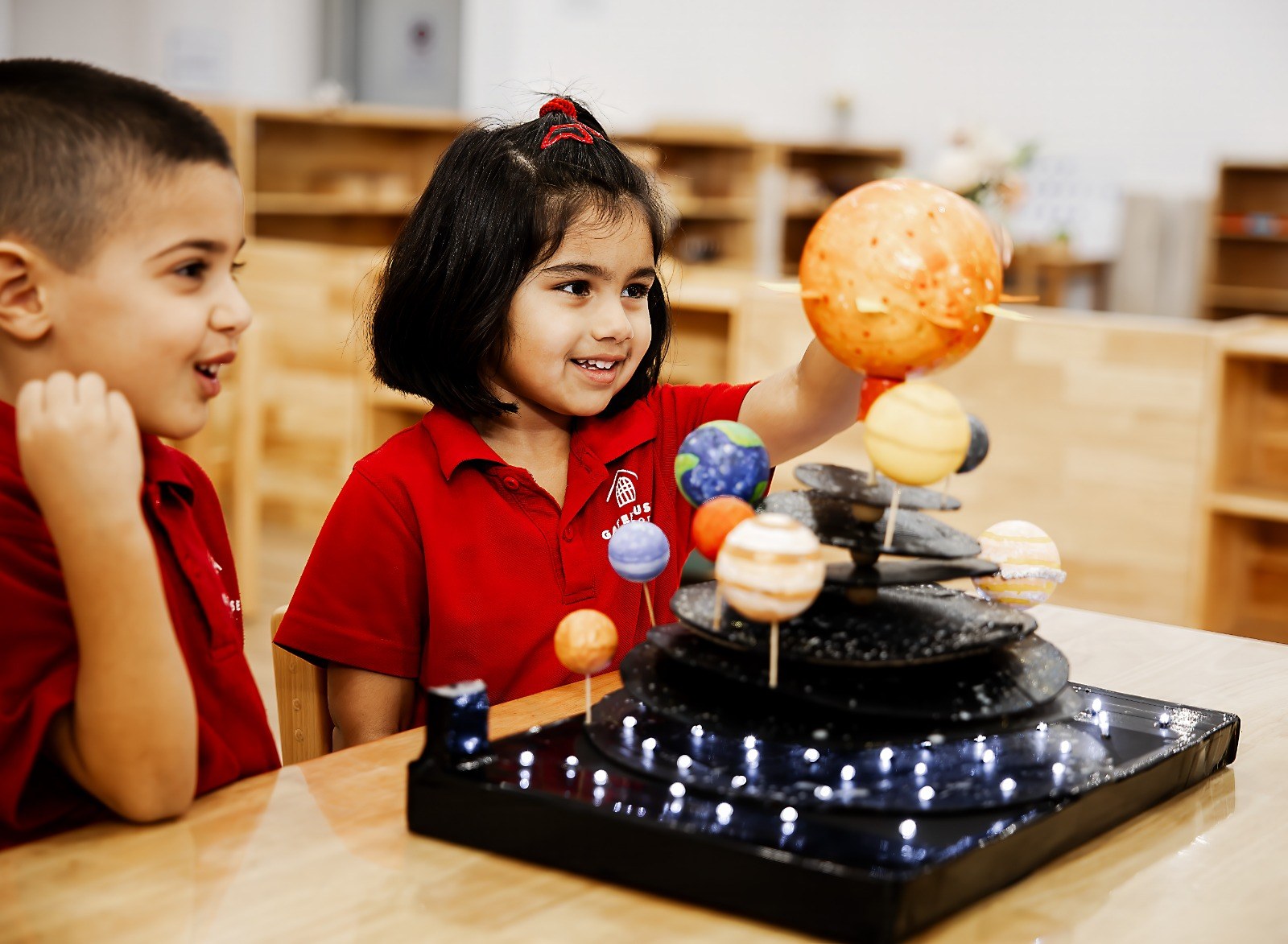 A child exploring a lit-up model of the solar system