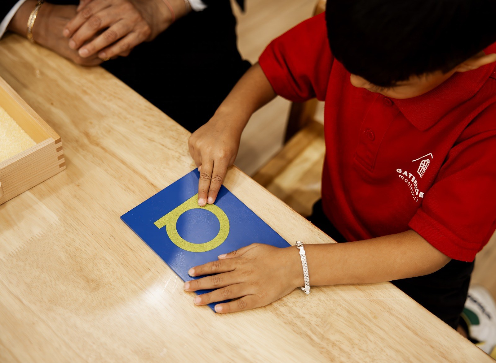 A child's hands practising writing in a notebook