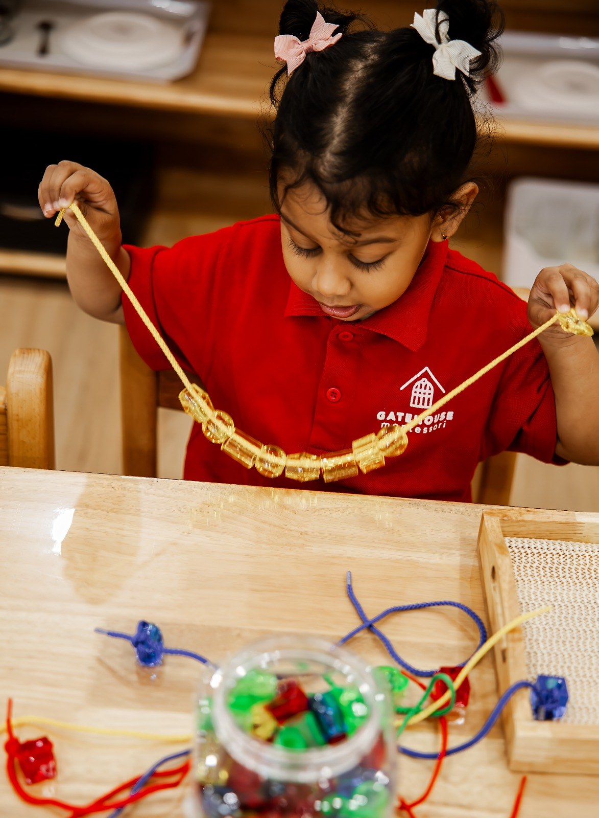 A child threading beads onto a string
