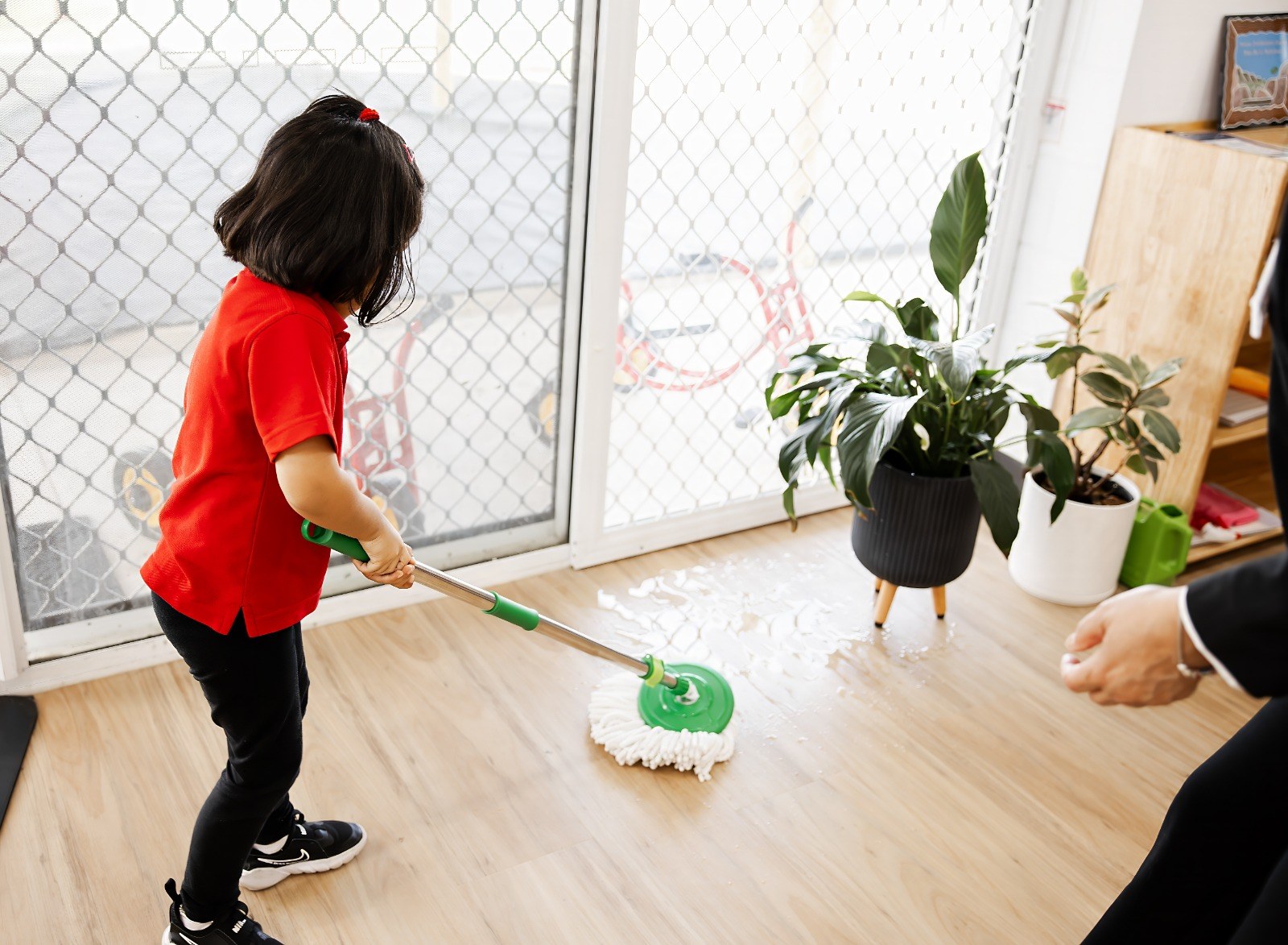 A child mopping the floor as a practical life activity