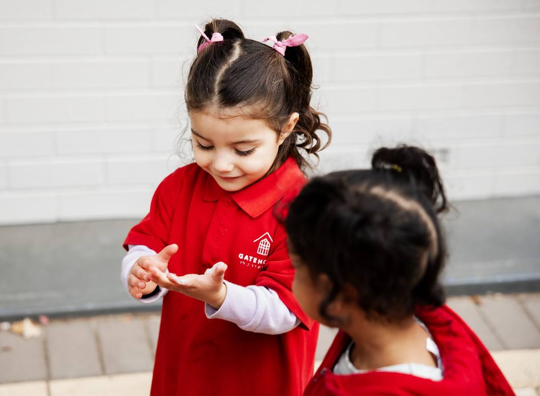 Children carrying watering cans outdoors